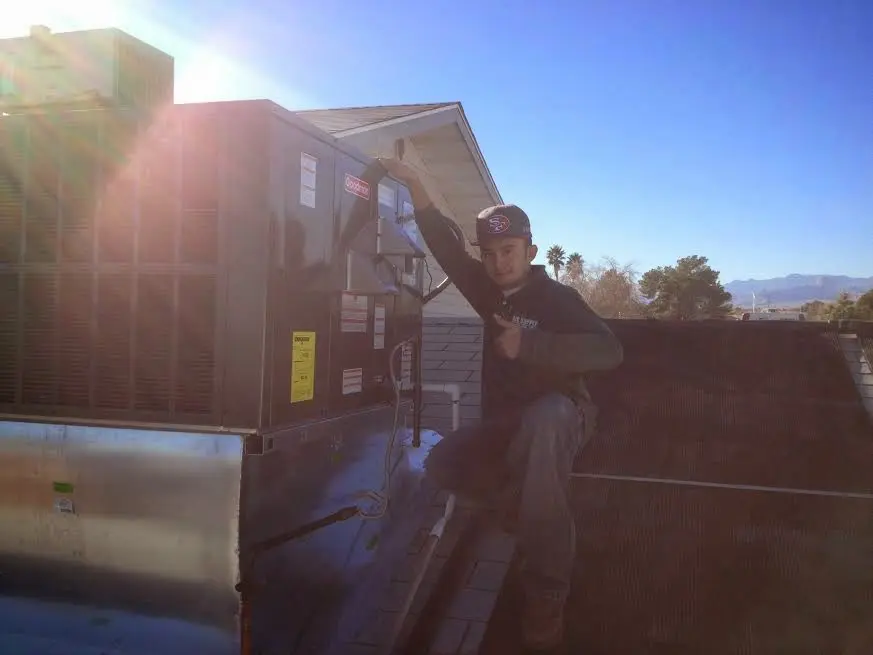 HVAC technician performing Air Duct Cleaning on a rooftop unit in Barberton